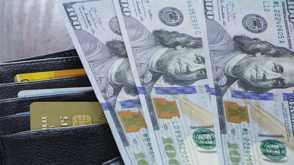 Yüz dolarlık banknotlar kredi kartlarının olduğu cüzdanda. Borç almak ya da Amerikan doları olarak kredi almak. Kasiyerdeki ödemenin hesaplanması. İş ve finans için ABD Doları ekonomisi.
