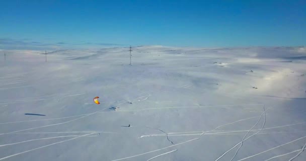 Vista aérea de la gente haciendo snowkiting en tundra. — Vídeos de Stock