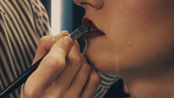 Profesyonel makyaj sanatçısı sarışın model yüzüne makyaj yapıyor. — Stok video