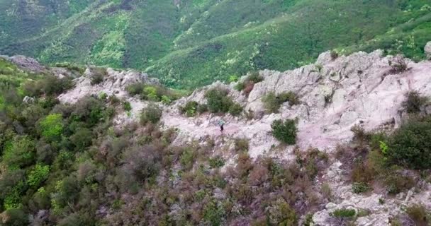Motorsikletini dağın tepesine çıkaran bir dağ bisikletçisinin hava görüntüsü.. — Stok video
