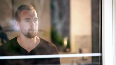 Onun evinde penceresinin arkasına yakışıklı adam