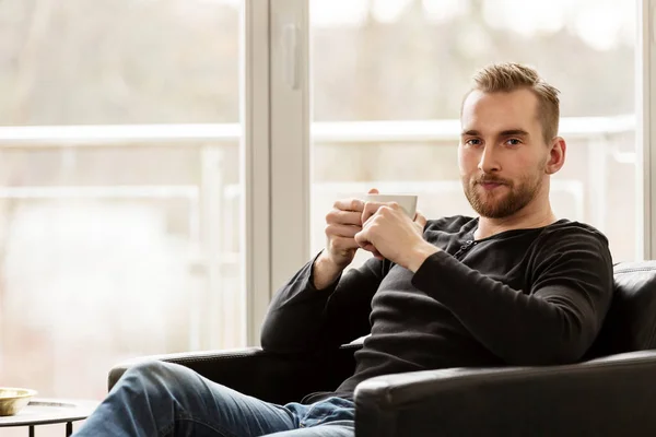 Schöner Mann mit Becher entspannt — Stockfoto