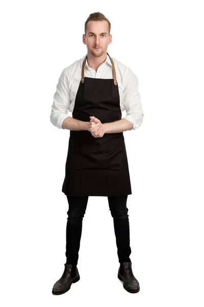 Красивий усміхнений шеф-кухар в білому і чорному, тримає 2 ножі і вуса, дивлячись на камеру, що стоїть на білому тлі . — стокове фото