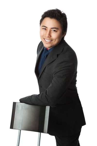 Smiling businessman leaning towards a chair — Stock Photo, Image