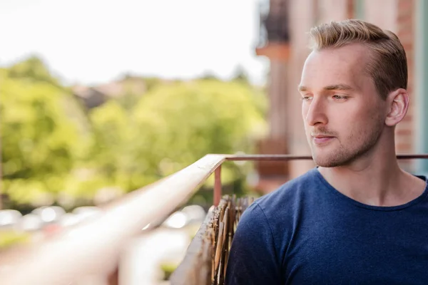 Aantrekkelijke man zit op zijn balkon — Stockfoto