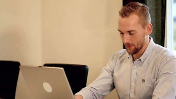 Aantrekkelijke man bezig met zijn computer thuis — Stockvideo