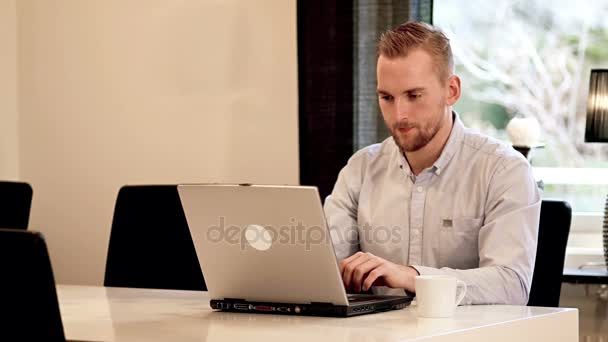 Ελκυστικό αρσενικό που εργάζεται στον υπολογιστή του στο σπίτι — Αρχείο Βίντεο
