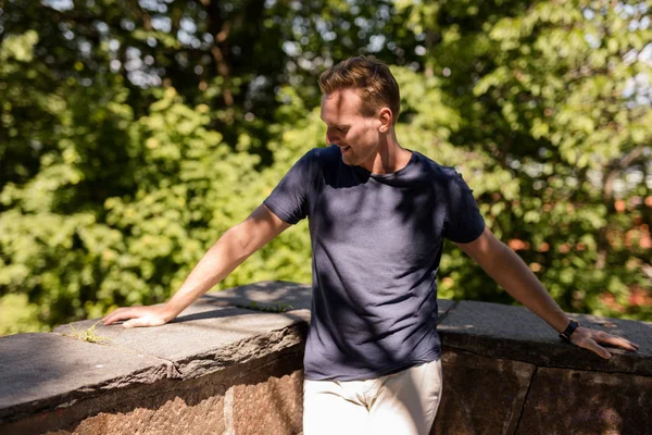 Hombre solitario en una camiseta de pie al aire libre en un parque —  Fotos de Stock