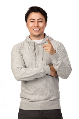 Çekici bir adam bir gri hood gömlek, kameraya bakarak gülen giyen bir beyaz arka plan ayakta kendi 20s.