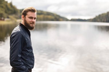 Sakal ayakta karşı kameraya açık havada güneşli bir günde seyir büyük bir göl ile geri adam koydu.