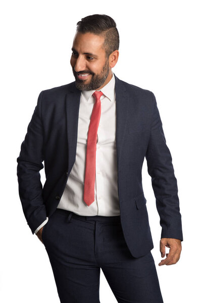 An attractive businessman in his 40s wearing a blue suit with a red tie, standing against a white background with a smile on his face.