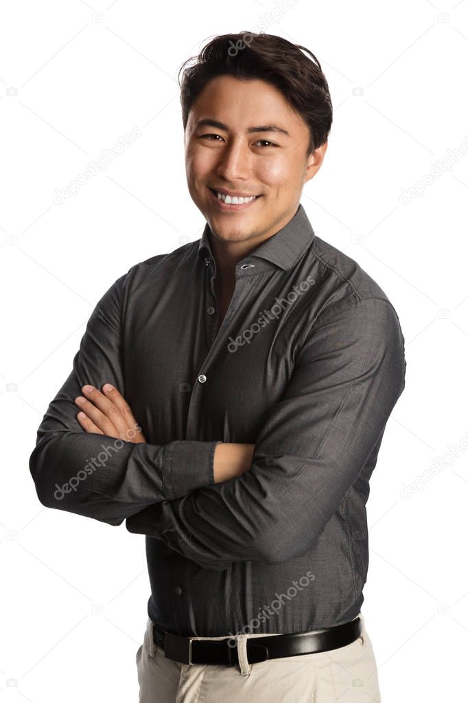 Handsome man in a grey shirt standing against a white background with a big smile on his face.