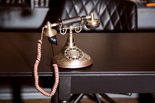 Old vintage antique candlestick telephone on the business working table working on the past.