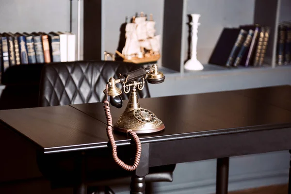 Old vintage antique candlestick telephone on the business working table working on the past.