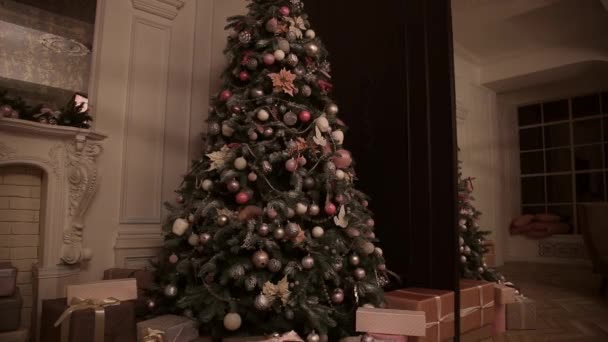 晚上房间里有圣诞树装饰 耀眼的闪光的花环散发着圣诞节的精神和心情 黑色房间 圣诞和新年室内装饰 绿树装饰着 — 图库视频影像