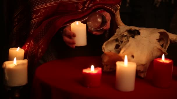 A woman holds a candle to perform a magical ritual. The witch casts a spell — ストック動画