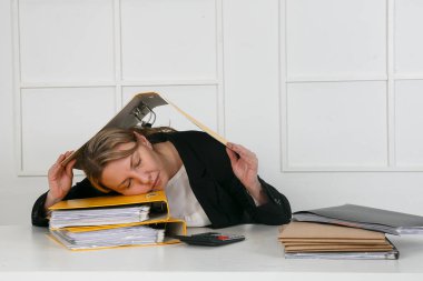 Finans tablosu hesap makinesiyle ofis masasında uyuyan bir işadamı.