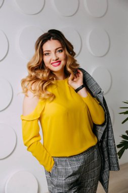 Mutlu, rahat, kendine güvenen genç iş kadını kollarını kavuşturmuş duruyor.