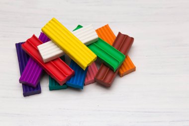 Birçok renkli plastik çubuklar beyaz arka planda yatar. Çocukların yaratıcılığı için. Boşluğu kopyala