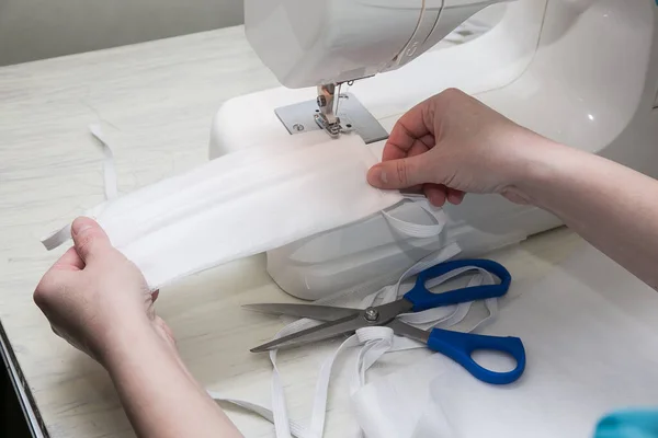 Evde dikiş makinesi var. Koronavirüsten korunması ve korunması gereken kişiler için maske üretimi ve dikiş ekipmanları Maske sıkıntısı çekenlere karşı