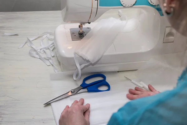 Volunteers and workers are making surgical masks for hospitals as an outbreak of COVID 19 causes a severe shortage of medical supplies. Production line of disposable medical masks