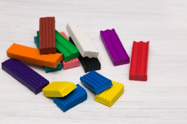 Beyaz arka planda renkli plasticin. Modellik için çok renkli plastikler, yakın çekim. Plastiğin karesi..