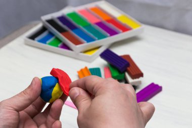 Beyaz arka planda renkli süper hafif plastik modelleme için havadar plastik kütle. Eller plastikle yontulmuş..