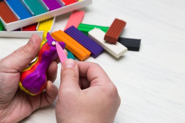 Beyaz arka planda renkli süper hafif plastik modelleme için havadar plastik kütle. Eller plastikle yontulmuş..