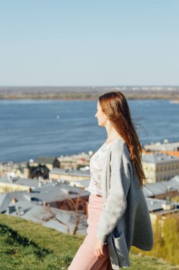 Beyaz hırkalı gülümseyen kadın portresi. Sokak, özgürlük ve mutluluğun arka planında gülen kız.