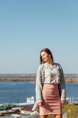 Beyaz hırkalı gülümseyen kadın portresi. Sokak, özgürlük ve mutluluğun arka planında gülen kız.