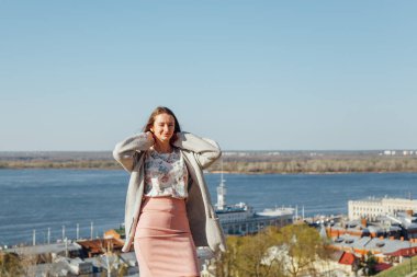 Beyaz hırkalı gülümseyen kadın portresi. Sokak, özgürlük ve mutluluğun arka planında gülen kız.