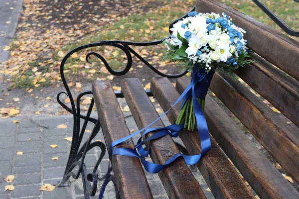 Bukiet Ślubny Białych Niebieskich Kwiatów Niebieską Wstążką Ciemnej Drewnianej Ławce — Zdjęcie stockowe
