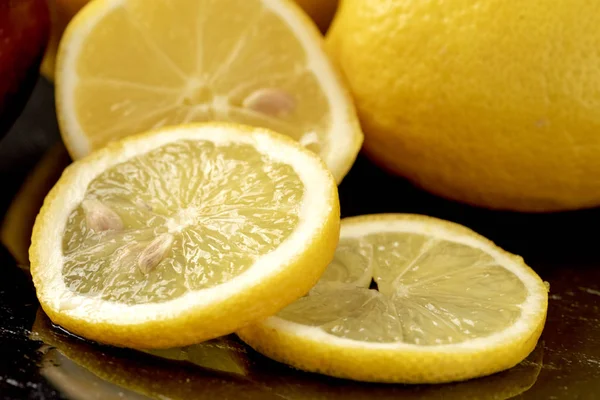 Fresh lemons with slices on dark background Stock Photo
