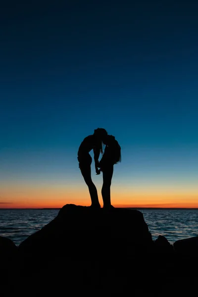 Couple girls staying on the stone. At the twilight — Stock Photo, Image