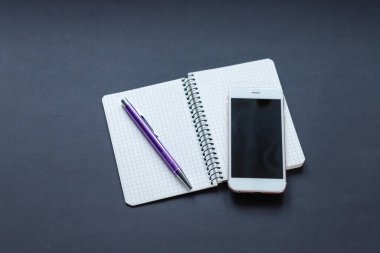 siyah arkaplan, kahve, kalem ve telefonlu defter