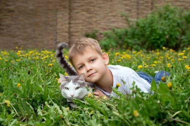 Çocuk ve kedi açık havada vardır
