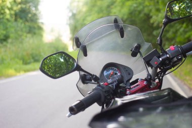 Orman bir asfalt yolda motosiklet binme sürücü.