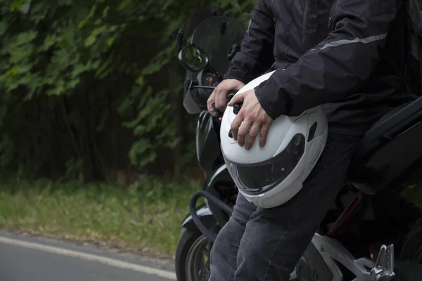 Řidič na koni motocyklu na asfaltové silnici lesem. — Stock fotografie