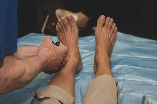 Ayak bileğine lokal anestezi yapan bir pediatrist ayağına cerrahi müdahale yapmadan önce.... 