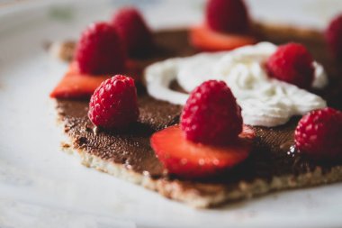 Fındıklı ve kremalı bir krepte ahududu ve çilek. 