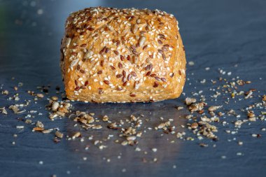 Karanlık bir arka planda, susam tohumlu bir somun ekmek.