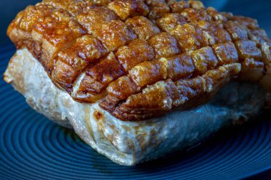 Kızarmış domuz eti. Siyah tabakta çatırdıyor. Yemeye hazır.