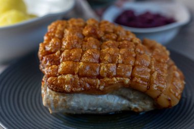 Kızarmış domuz eti. Siyah tabakta çatırdıyor. Yemeye hazır.