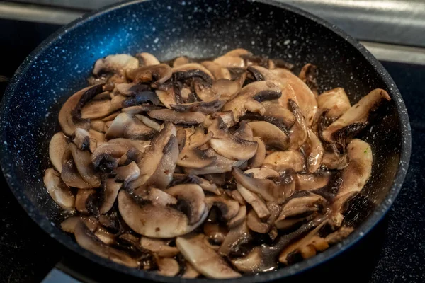 İnce dilimlenmiş taze çiğ mantarlar yakın plan çekimde kızartılır. Sağlıklı beslenme