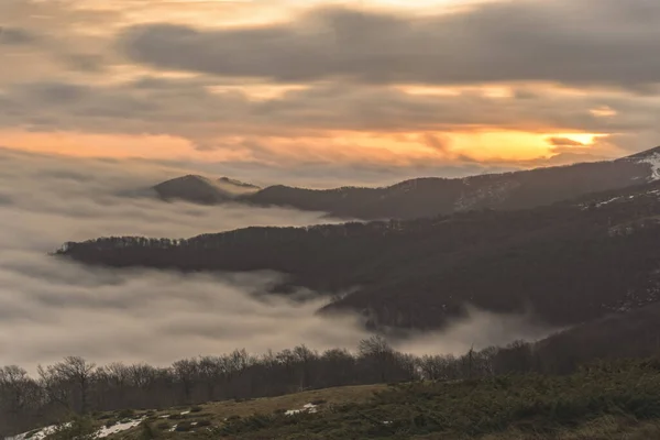 Foggy mountains at sunrise at long exposure — Stock Photo, Image