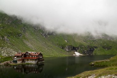 Sibiu County 'deki Chalet ve Glacier Gölü sisli ve yansımalı.