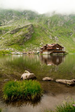 Sibiu County 'deki Chalet ve Glacier Gölü sisli ve yansımalı.