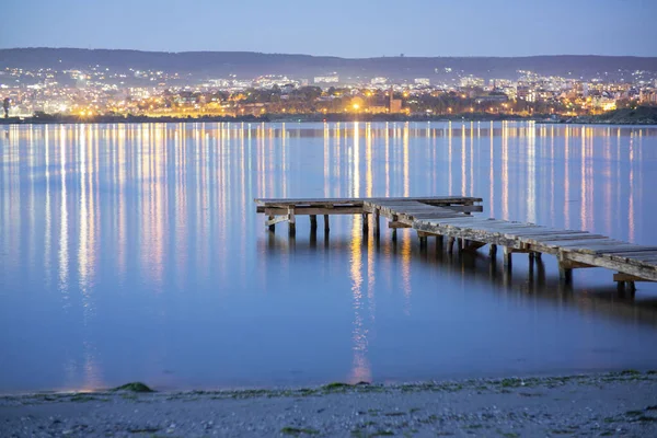 背景の街と夜の空の釣り桟橋 — ストック写真