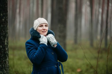 Sevimli Avrupalı Letonyalı kadın portresi mutlu ve gülümsüyor sahte kürk ve koyu mavi ceket ve başlık giyiyor