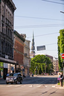 Riga, Letonya - Mai 26, 2018: Riga 'daki cadde ve park yakınlarındaki binaların işlek manzarası - öğlen kent manzarası. Aziz Peter Kilisesi (Rigas Sv. Petera baznica), Riga 'nın merkezinde yer almaktadır.